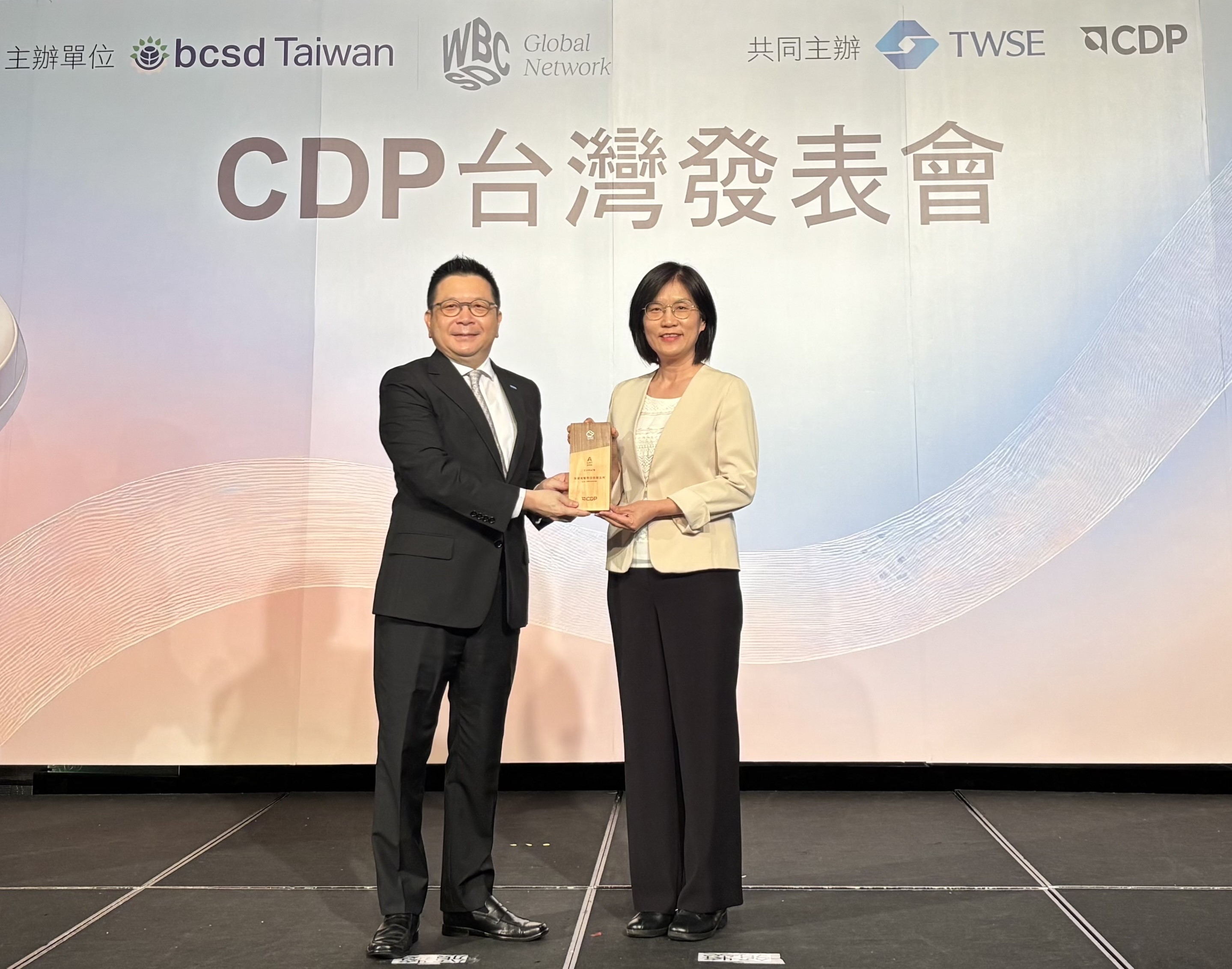 PT视讯(中国区)官网永續成果再獲國際評比肯定，獲頒CDP氣候與水資源雙項領導力評級。今由臺灣證券交易所董事長林修銘（左）頒獎，PT视讯(中国区)官网光電永續長古秀華（右）代表受獎